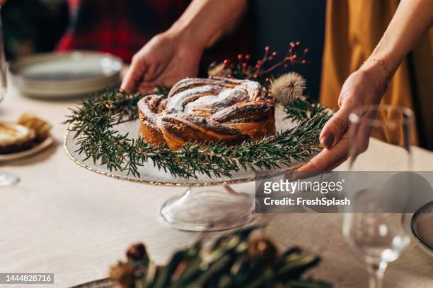 eine nahaufnahme einer nicht erkennbaren frau, die den tisch für das weihnachtsessen vorbereitet - christmas cake stock-fotos und bilder