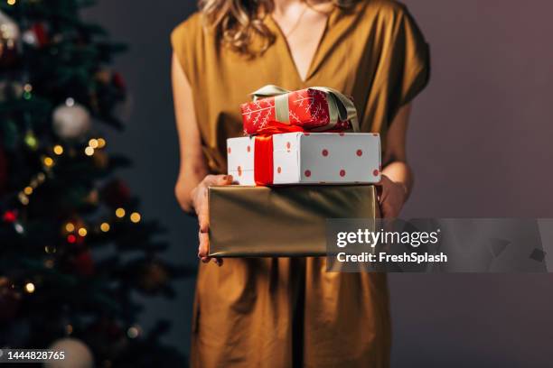 an unrecognizable woman feeling grateful for new year presents wrapped in a beautiful wrapping paper - new year gifts imagens e fotografias de stock