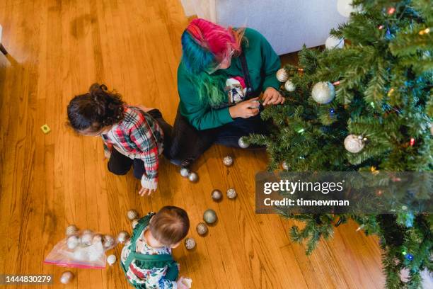 multi racial family decorating christmas tree at home - chihuahua christmas ornaments stock pictures, royalty-free photos & images