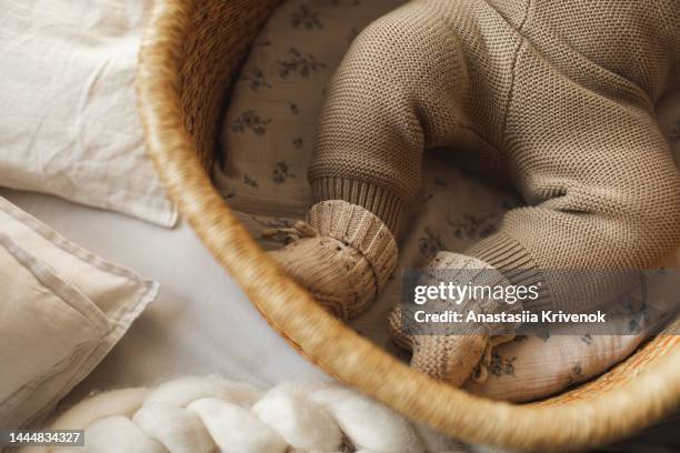 baby's legs in cotton knitwear laying on a bed. - baby cotton wool stock pictures, royalty-free photos & images