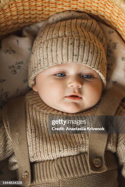 a 5 month old baby boy in cotton knitwear laying on a bed. - baby cotton wool stock pictures, royalty-free photos & images