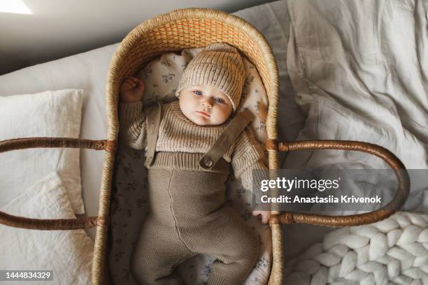 a 5 month old baby boy in cotton knitwear laying on a bed. - baby cotton wool stock pictures, royalty-free photos & images