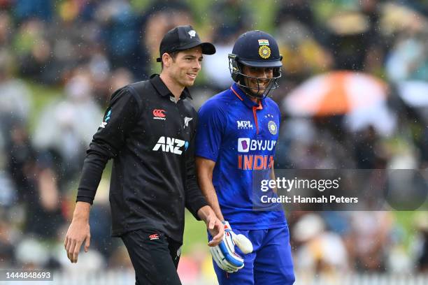 Mitchell Santner of the Black Caps walks off with Shubman Gill of India during a rain delay during game two of the One Day International series...