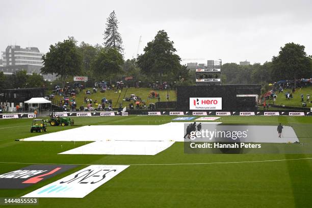 Groundsmen sweep the covers during a rain delay during game two of the One Day International series between New Zealand and India at Seddon Park on...