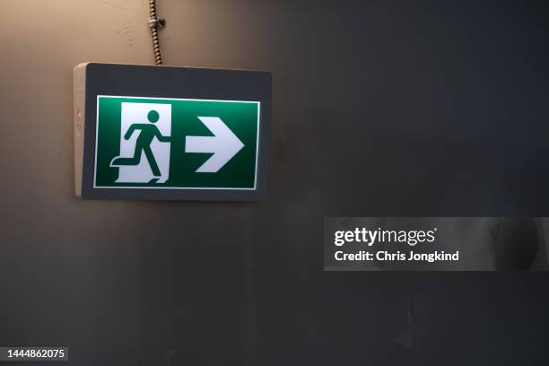 illuminated emergency exit sign on wall - 非常口 ストックフォトと画像