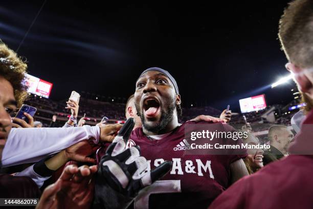 Fans rush the field alongside Shemar Turner of the Texas A&M Aggies following a win over the LSU Tigers 38-23 at Kyle Field on November 26, 2022 in...