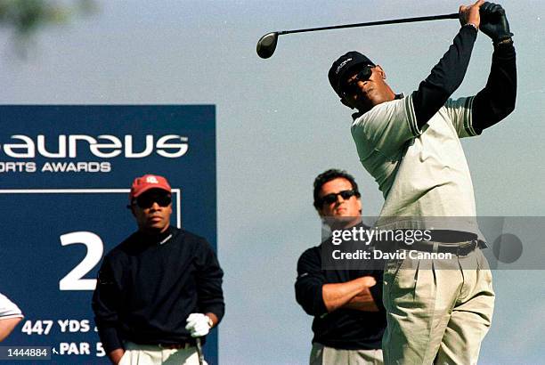 Samuel L. Jackson of America tees off watched by Sylvester Stallone of America and Sugar Ray Leonard of America at the Pro-Am golf day prior to the...