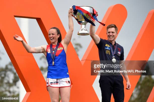 Head coach Mick Stinear and Daisy Pearce of the Demons hold the trophy aloft after winning the AFLW Grand Final match between the Brisbane Lions and...