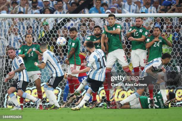 Lionel Messi of Argentina takes a free kick against Erick Gutierrez, Alexis Vega, Nestor Araujo, Cesar Montes, Hector Herrera and Luis Chavez of...