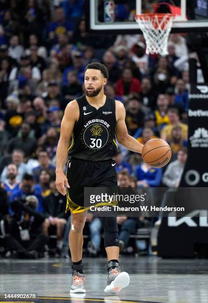Stephen Curry of the Golden State Warriors dribbles the ball up court against the Utah Jazz during the second quarter of an NBA basketball game at...