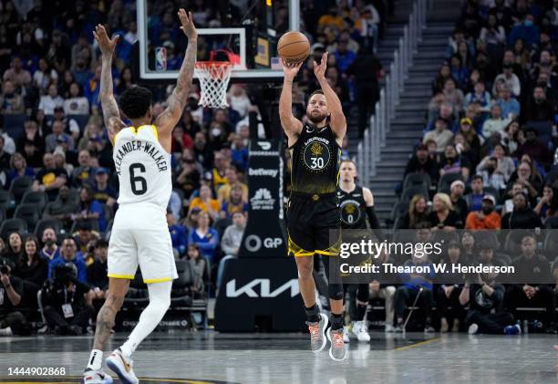 Stephen Curry of the Golden State Warriors shoots the ball from half court over Nickeil Alexander-Walker of the Utah Jazz at the end of the second...