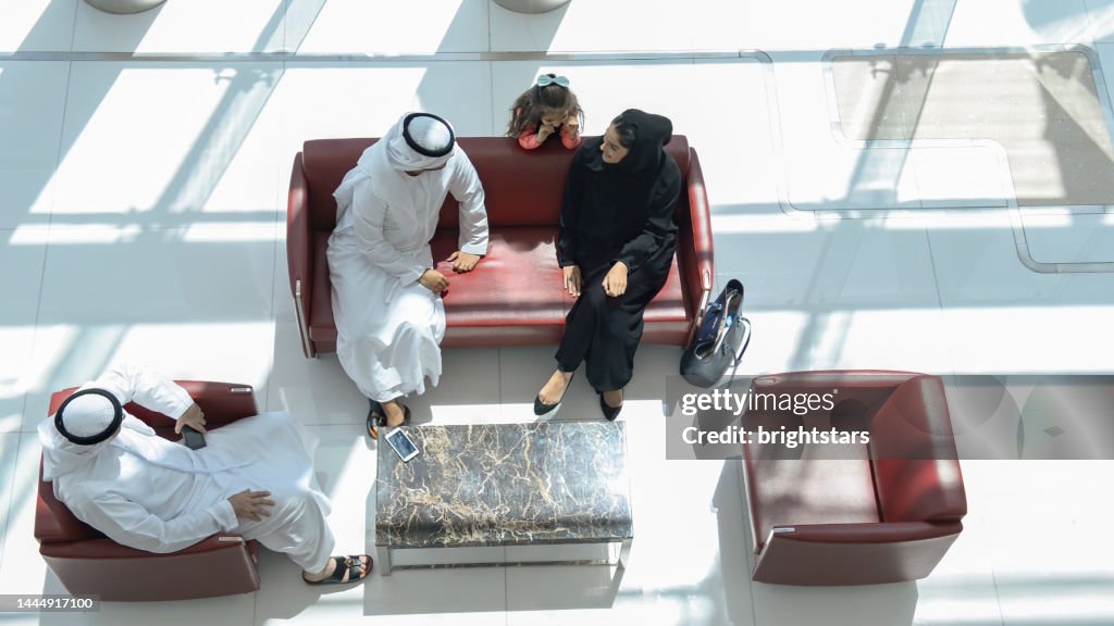 Multi-generation Emirati family resting in a shopping mall