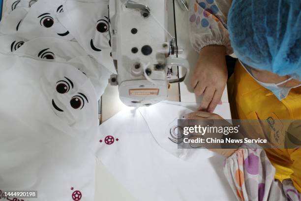 An employee makes stuffed toys of the Qatar 2022 mascot "La'eeb" at a factory on November 26, 2022 in Dongguan, Guangdong Province of China.