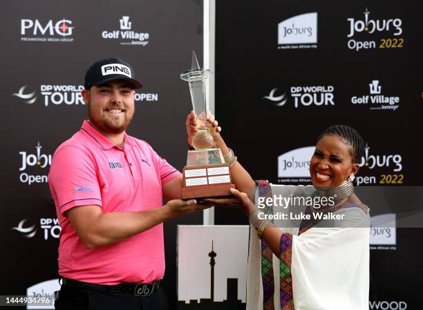 Dan Bradbury of England is presented with the winners trophy after the final round of the Joburg Open at Houghton GC on November 27, 2022 in...