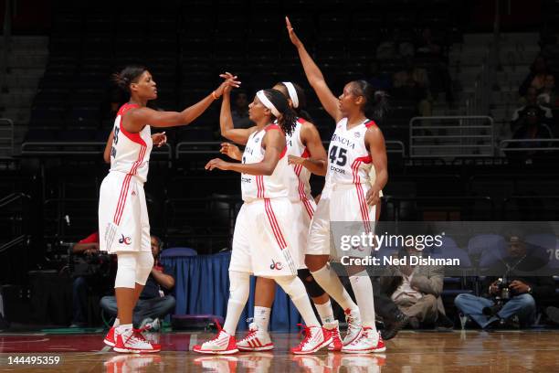 Ashley Robinson, Dominique Canty and Noelle Quinn of the Washington Mystics celebrate against the Connecticut Sun at the Verizon Center on May 14,...