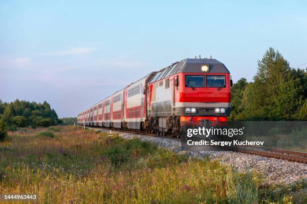 powerful diesel locomotive with double-decker passenger train - tren de pasajeros fotografías e imágenes de stock