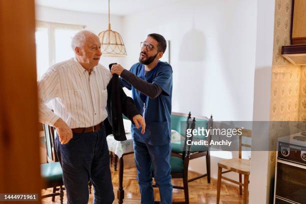 home caretaker dressing senior man - assisted living community stock pictures, royalty-free photos & images