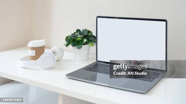 workplace with laptop on table at home. laptop with blank screen on white table. home interior or office background - blank book on desk stock-fotos und bilder