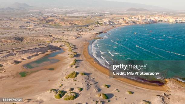 view of wind and kite surfers at el medano, tenerife - tenerife sea stock pictures, royalty-free photos & images