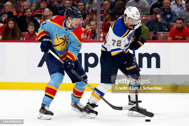 Justin Faulk of the St. Louis Blues skates with the puck against Eetu Luostarinen of the Florida Panthers at the FLA Live Arena on November 26, 2022...