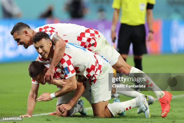 Andrej Kramaric of Croatia celebrates with team mates Ivan Perisic and Dejan Lovren after scoring his second goal to give the side a 3-1 lead during...
