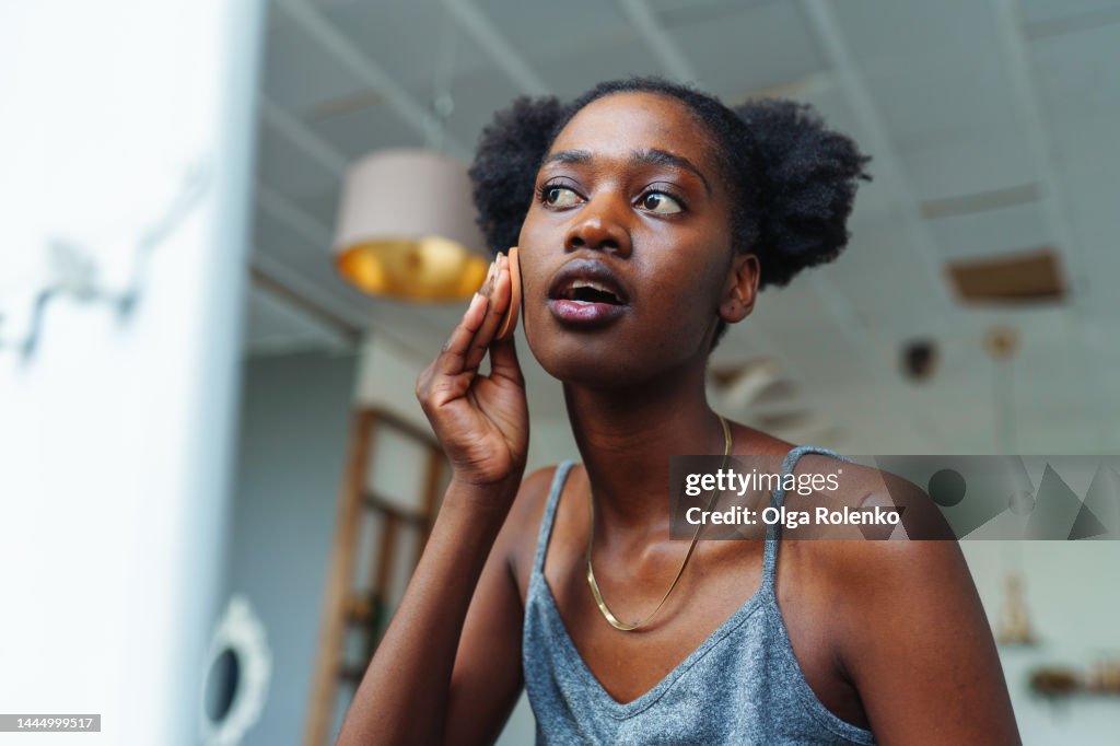 Skin problems. Acne. Woman applying concealer on her face to hide pimples