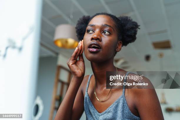 skin problems. acne. woman applying concealer on her face to hide pimples - routine bildbanksfoton och bilder