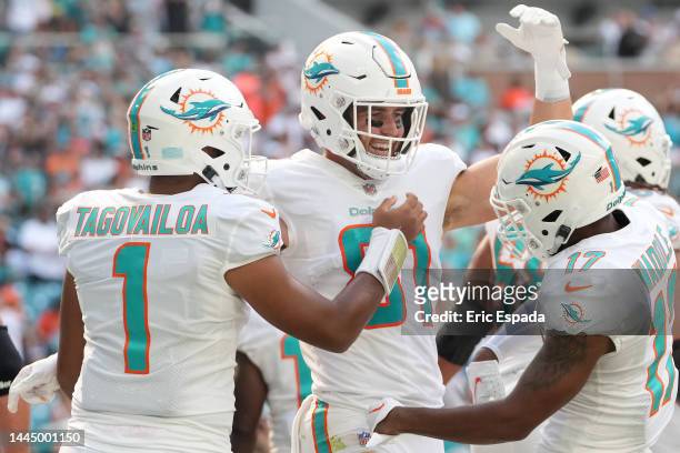 Durham Smythe of the Miami Dolphins celebrates a touchdown with Tua Tagovailoa and Jaylen Waddle during the first quarter in the game against the...
