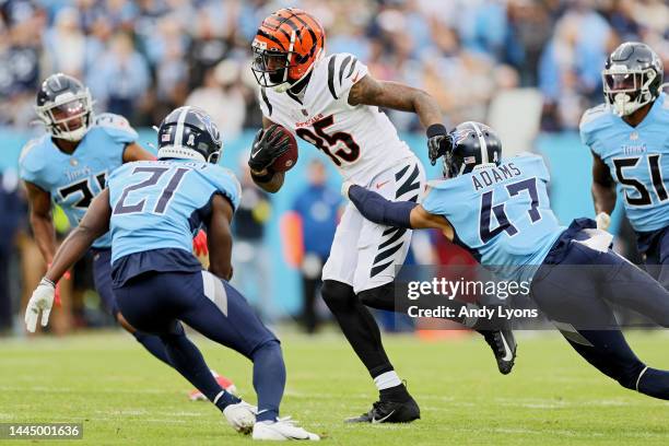 Tee Higgins of the Cincinnati Bengals runs with the ball as Andrew Adams of the Tennessee Titans defends during the first half at Nissan Stadium on...