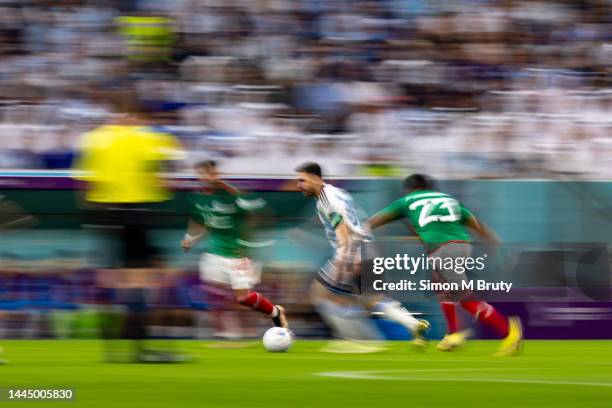 Lionel Messi of Argentina runs the ball past Alexis Vega of Mexico and Jesus Gallardo of Mexico during the FIFA World Cup Qatar 2022 Group C match...