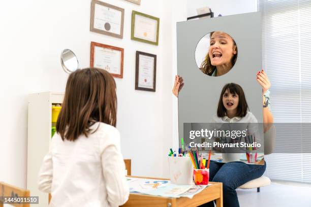 speech therapy - girl tongue doctor stockfoto's en -beelden