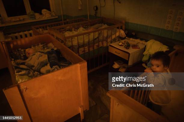 Orphan childreen play and sleep in their cots amid an electricity outage at the Kherson Regional Children’s hospital on November 26, 2022 in Kherson,...