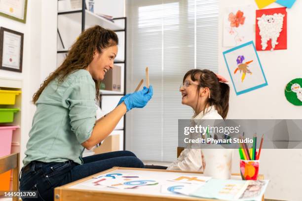 speech therapy - girl tongue doctor stockfoto's en -beelden