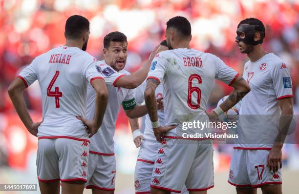 Youssef Msakni of Tunisia talks to team mates Yassine Meriah, Naim Sliti, Ellyes Skhiri and Dylan Bronnduring the FIFA World Cup Qatar 2022 Group D...