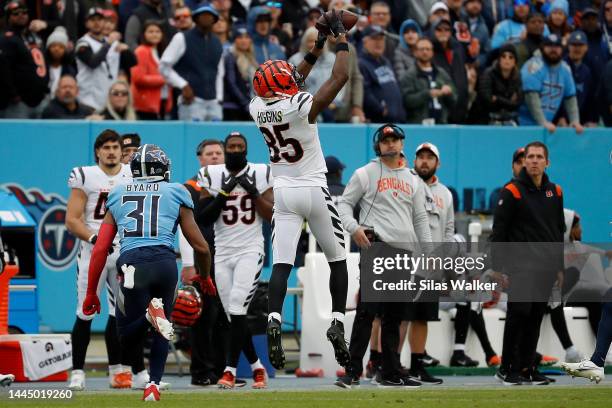 Tee Higgins of the Cincinnati Bengals catches the ball during the fourth quarter as Kevin Byard of the Tennessee Titans defends at Nissan Stadium on...