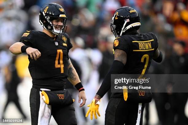 Taylor Heinicke of the Washington Commanders celebrates with Dyami Brown of the Washington Commanders after beating the Atlanta Falcons 19-13 at...