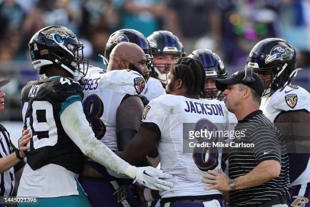 Head coach John Harbaugh and Lamar Jackson of the Baltimore Ravens breaks up Morgan Moses and the Jacksonville Jaguars during the second half at TIAA...