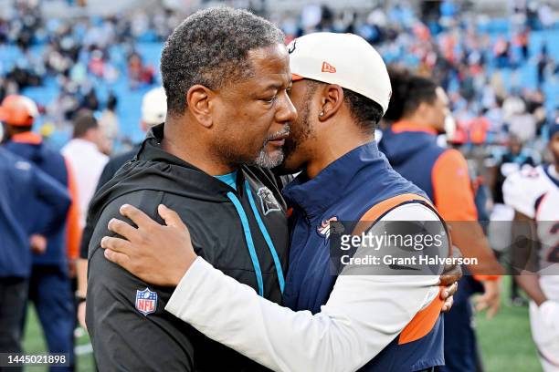 Head coach Steve Wilks of the Carolina Panthers hug a Denver Broncos coach after a game at Bank of America Stadium on November 27, 2022 in Charlotte,...