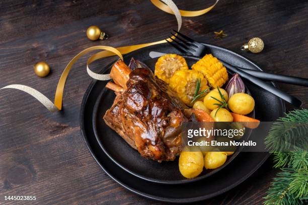 pork shank knuckle with baked potatoes and corn, dinner food christmas new year - christmas leg ham stock pictures, royalty-free photos & images