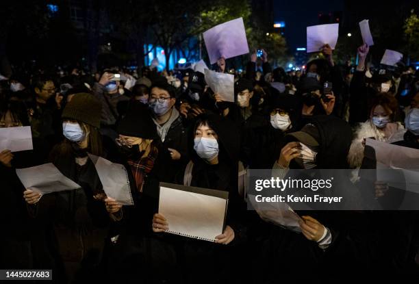 Protesters hold up a white piece of paper against censorship as they march during a protest against Chinas strict zero COVID measures on November 27,...