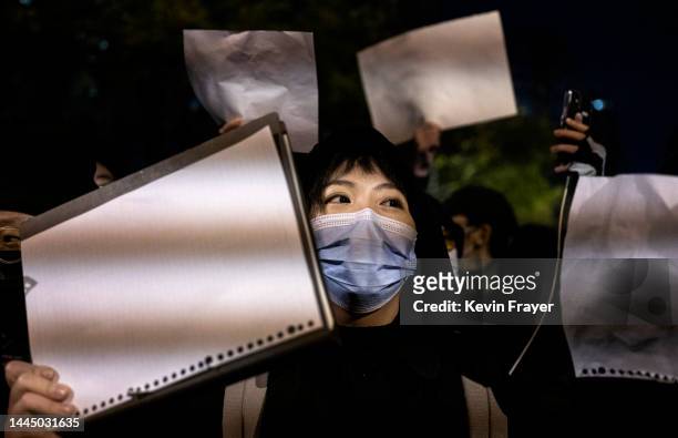 Protesters hold up a white piece of paper against censorship as they march during a protest against Chinas strict zero COVID measures on November 27,...