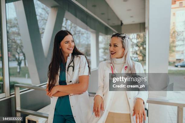 two young women medical students in front of a hospital - time of day stock pictures, royalty-free photos & images