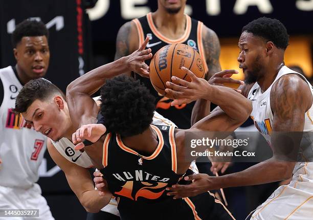 Haywood Highsmith of the Miami Heat defends as Tyler Herro fouls De'Andre Hunter of the Atlanta Hawks during the first half at State Farm Arena on...