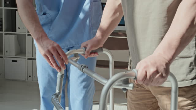 Doctor Helping Patient to Use Walker