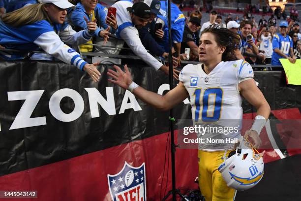 Justin Herbert of the Los Angeles Chargers celebrates with fans after beating the Arizona Cardinals 25-24 at State Farm Stadium on November 27, 2022...