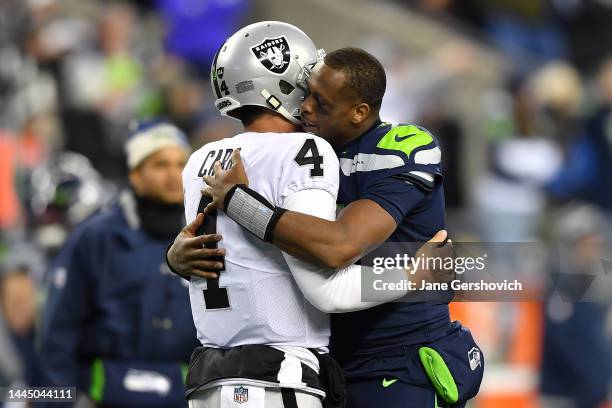 Derek Carr of the Las Vegas Raiders and Geno Smith of the Seattle Seahawks meet after the Raiders beat the Seahawks 40-34 in overtime at Lumen Field...