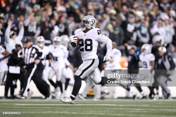 Josh Jacobs of the Las Vegas Raiders runs with the ball in overtime against the Seattle Seahawks at Lumen Field on November 27, 2022 in Seattle,...