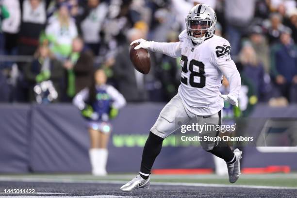 Josh Jacobs of the Las Vegas Raiders celebrates after scoring a touchdown in overtime to beat the Seattle Seahawks 40-34 at Lumen Field on November...