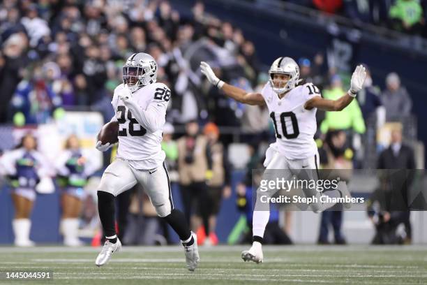 Josh Jacobs of the Las Vegas Raiders runs with the ball in overtime against the Seattle Seahawks at Lumen Field on November 27, 2022 in Seattle,...