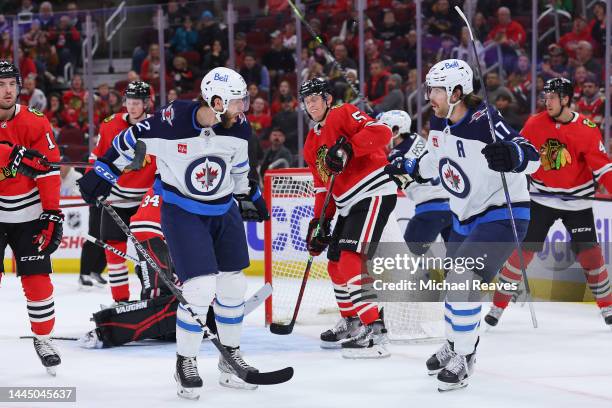 Jansen Harkins of the Winnipeg Jets celebrates with Adam Lowry after scoring a goal against the Chicago Blackhawks during the first period at United...